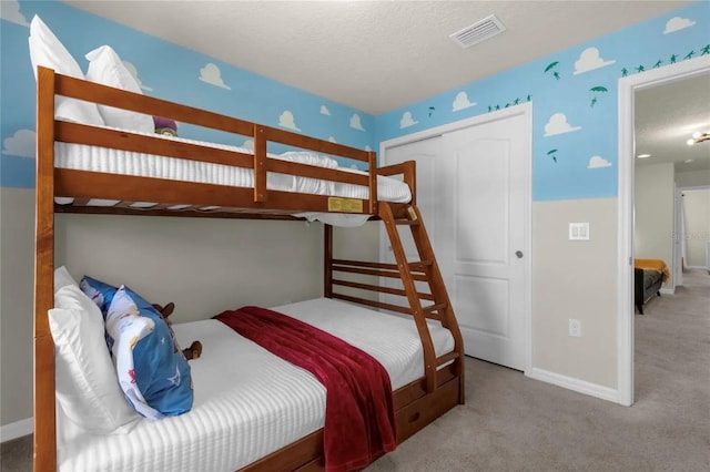 bedroom with a textured ceiling and light carpet