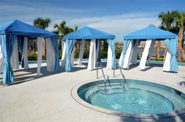 view of pool with a community hot tub, a patio area, and a gazebo