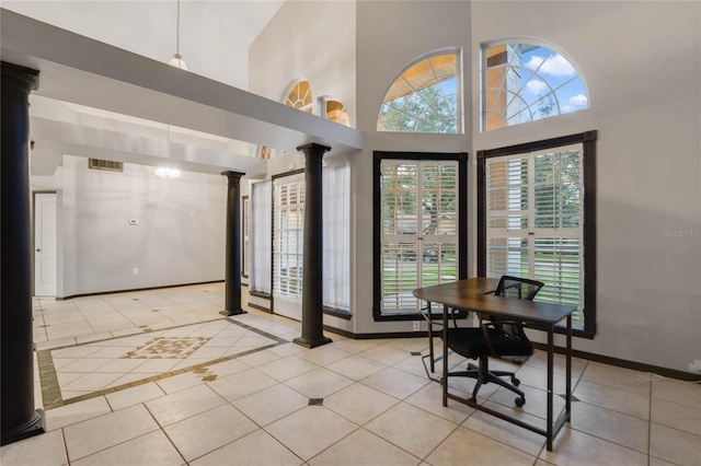 doorway with light tile patterned floors and decorative columns