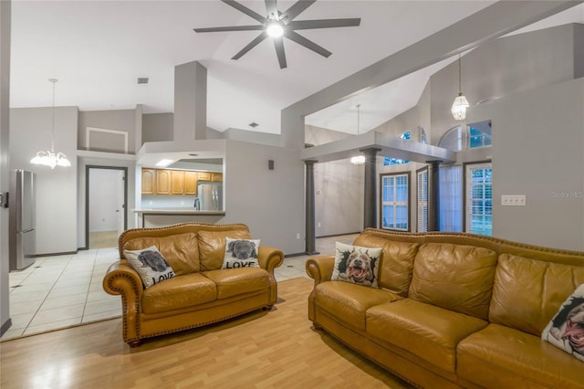 living room with light hardwood / wood-style flooring, high vaulted ceiling, and decorative columns