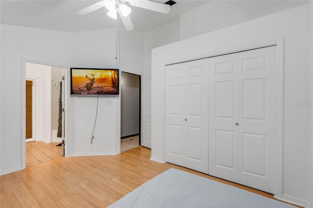 bedroom featuring light wood-type flooring, ceiling fan, and a closet