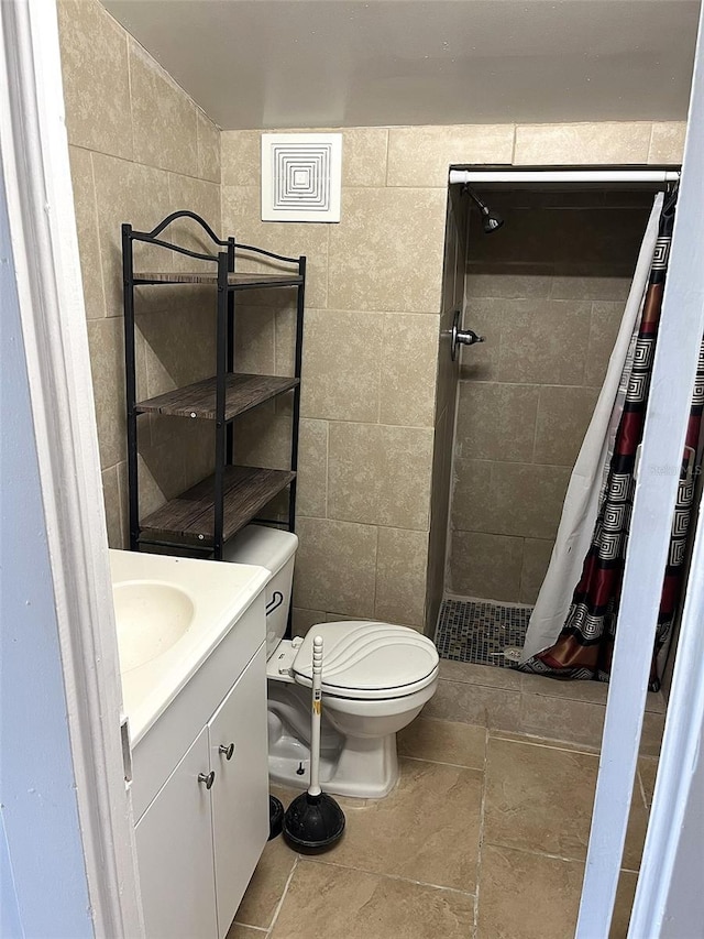 bathroom featuring tile walls, vanity, and toilet