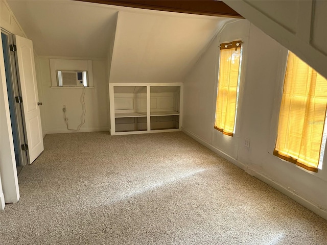 additional living space with carpet, vaulted ceiling, and a wall mounted AC