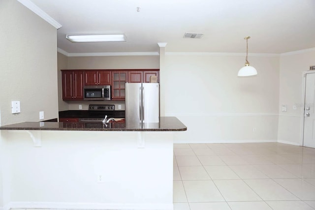 kitchen with kitchen peninsula, appliances with stainless steel finishes, a breakfast bar area, hanging light fixtures, and crown molding