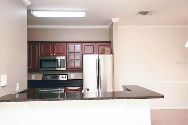 kitchen with ornamental molding, kitchen peninsula, appliances with stainless steel finishes, and light tile patterned floors