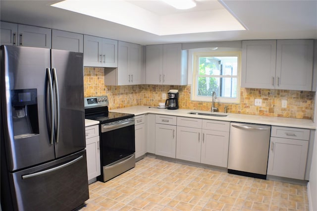 kitchen with gray cabinets, tasteful backsplash, appliances with stainless steel finishes, and sink