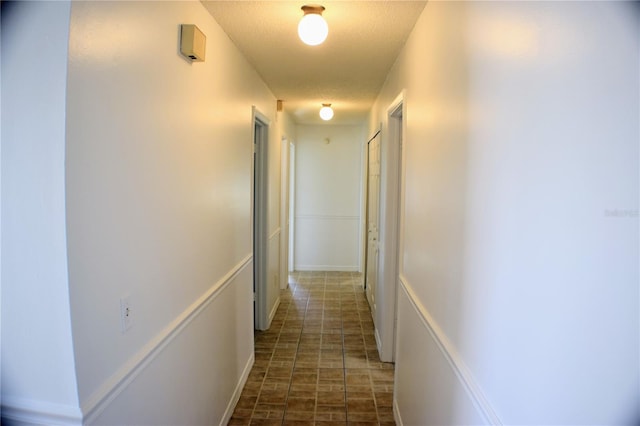 hall featuring a textured ceiling