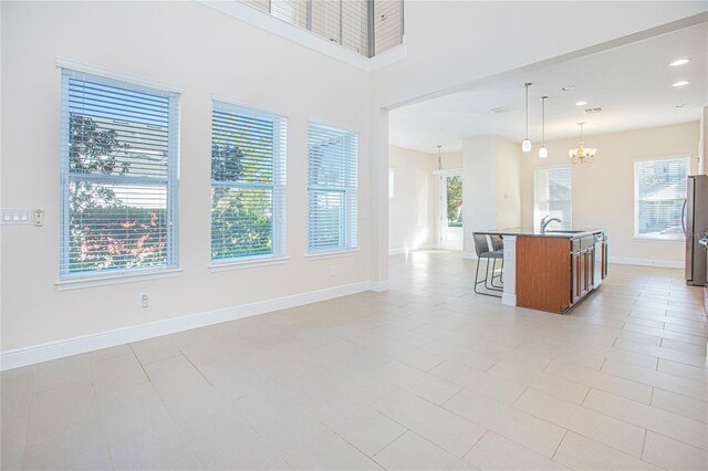 interior space with a kitchen island with sink, plenty of natural light, and pendant lighting