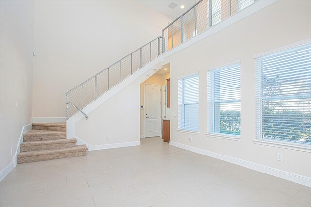 unfurnished living room with a high ceiling