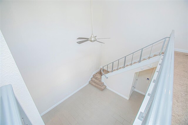 stairway featuring ceiling fan