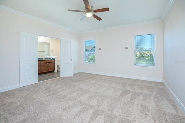 carpeted spare room with crown molding, plenty of natural light, and ceiling fan