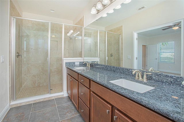 bathroom with tile patterned flooring, vanity, an enclosed shower, and ceiling fan