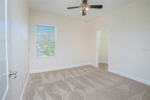 carpeted spare room with ceiling fan