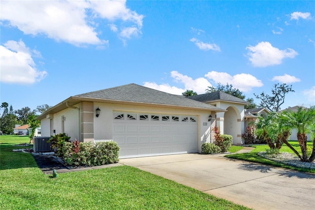 view of front facade with a front yard, central AC unit, and a garage