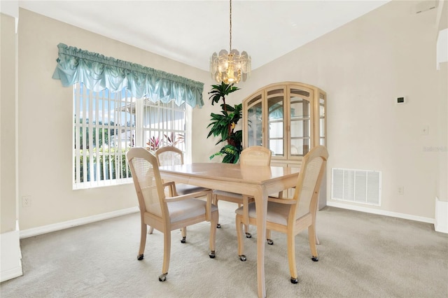 dining space with light carpet and a notable chandelier