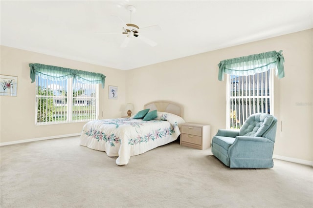 carpeted bedroom with ceiling fan and multiple windows