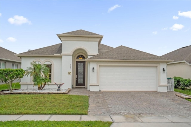 4001 Scarlet Branch Rd, Orlando, FL 32824 - view of front facade with a garage, decorative driveway, stucco siding, and roof with shingles