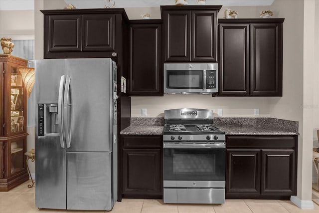 4001 Scarlet Branch Rd, Orlando, FL 32824 - kitchen with appliances with stainless steel finishes, light tile patterned floors, and dark stone counters