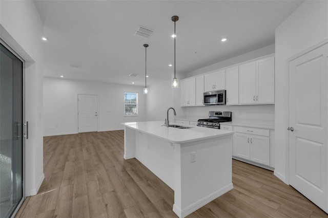 kitchen with pendant lighting, white cabinetry, stainless steel appliances, and sink