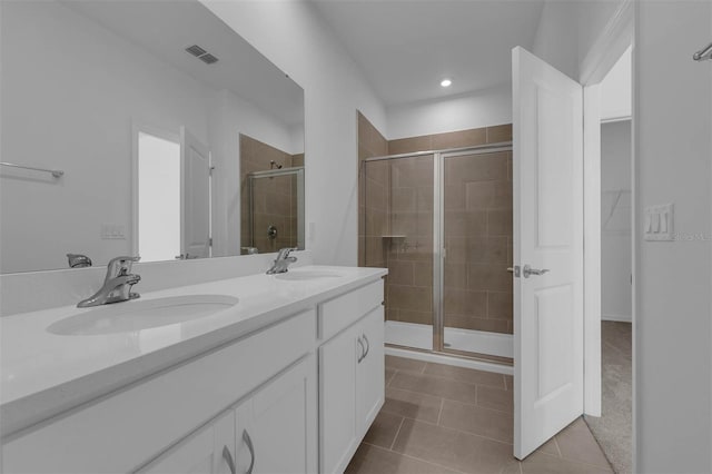 bathroom featuring a shower with door, vanity, and tile patterned flooring