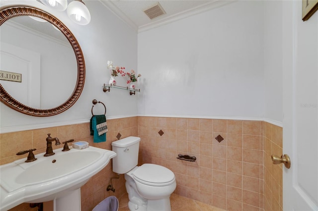 bathroom with tile walls, crown molding, sink, tile patterned flooring, and toilet