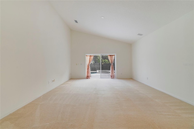 carpeted empty room with lofted ceiling