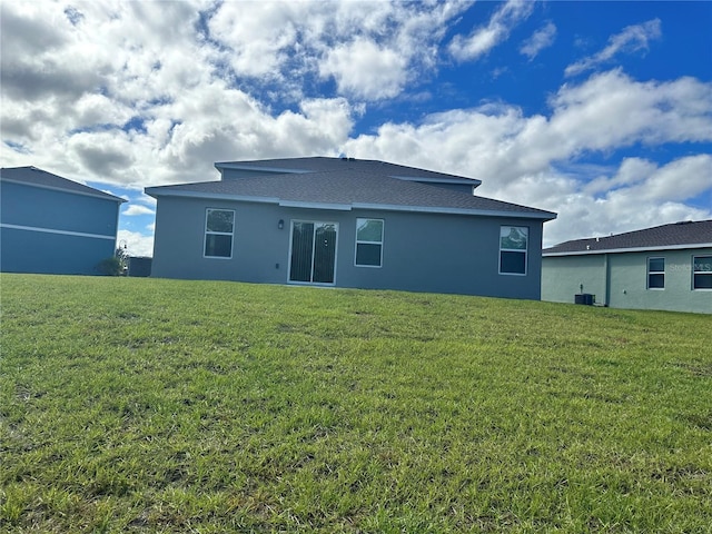 back of property featuring central AC unit and a lawn