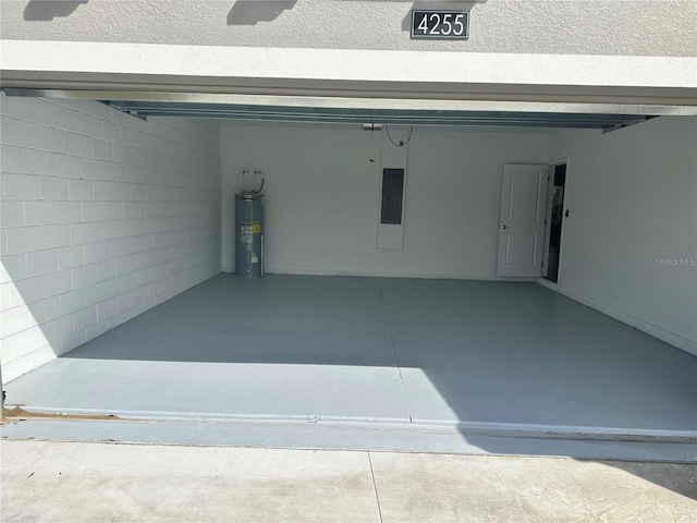 garage featuring electric panel and water heater