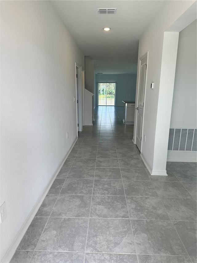 hallway with tile patterned flooring