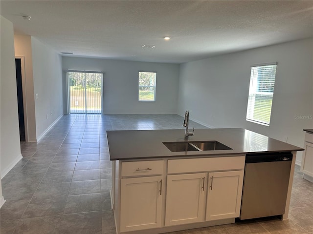 kitchen featuring light tile patterned flooring, a center island with sink, sink, white cabinets, and dishwasher