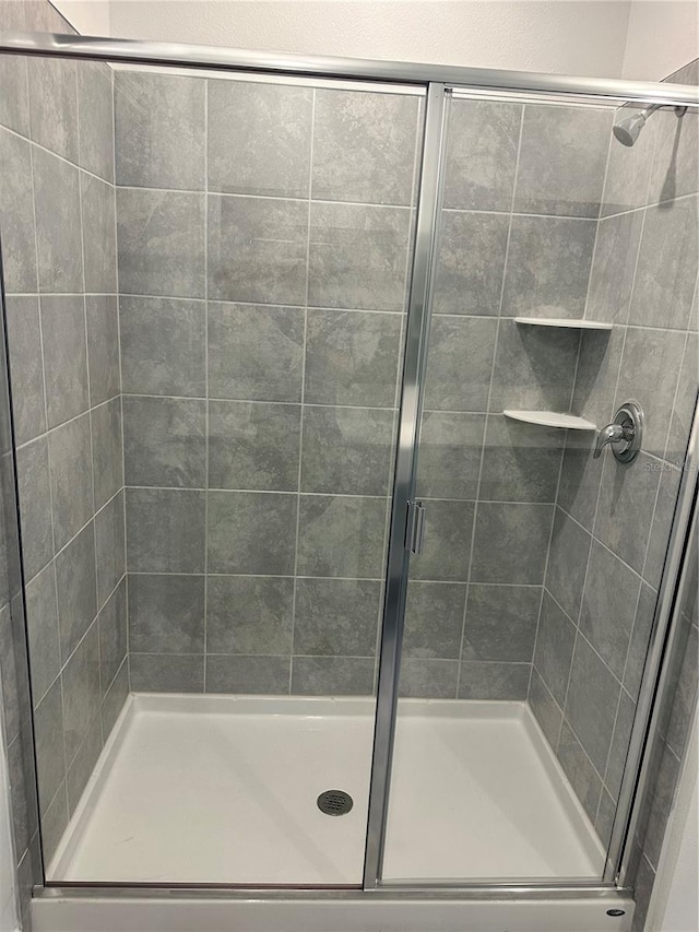 bathroom with a shower with door