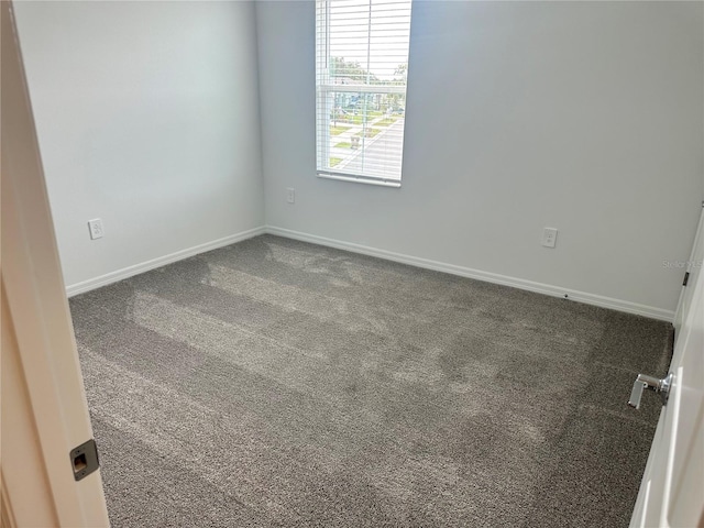 unfurnished room featuring dark carpet