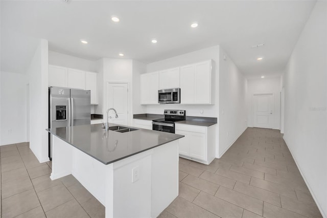 kitchen with appliances with stainless steel finishes, sink, an island with sink, and white cabinets