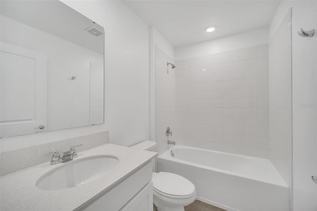 full bathroom featuring vanity, tiled shower / bath combo, and toilet