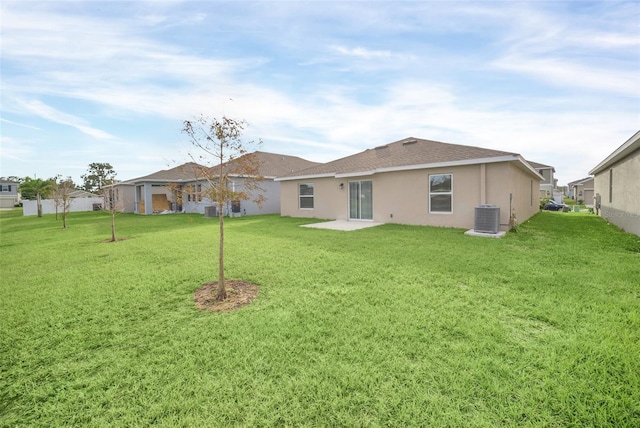 rear view of property featuring a yard and cooling unit