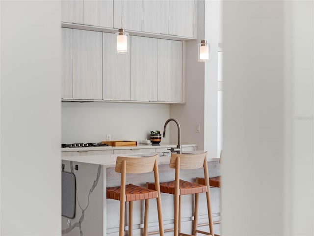 kitchen with pendant lighting, white gas cooktop, and hardwood / wood-style flooring