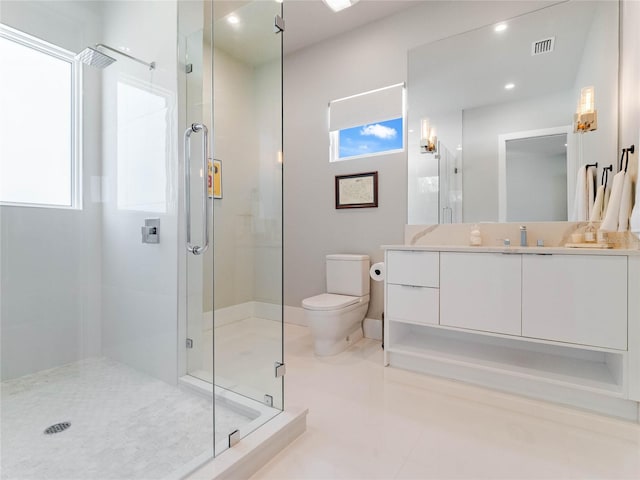 bathroom with tile patterned flooring, vanity, a shower with shower door, and a wealth of natural light