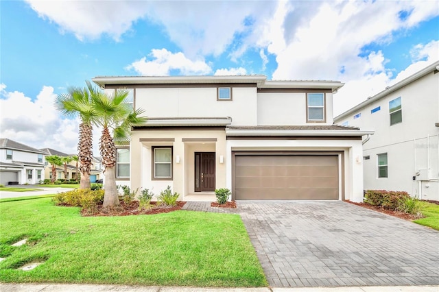 view of property with a garage and a front lawn