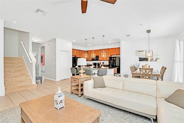 tiled living room with ceiling fan