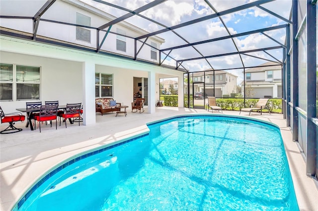 view of swimming pool featuring glass enclosure and a patio