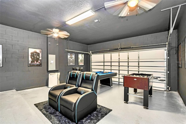 game room featuring ceiling fan, concrete flooring, and a textured ceiling