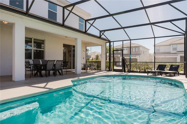 view of pool featuring glass enclosure and a patio area