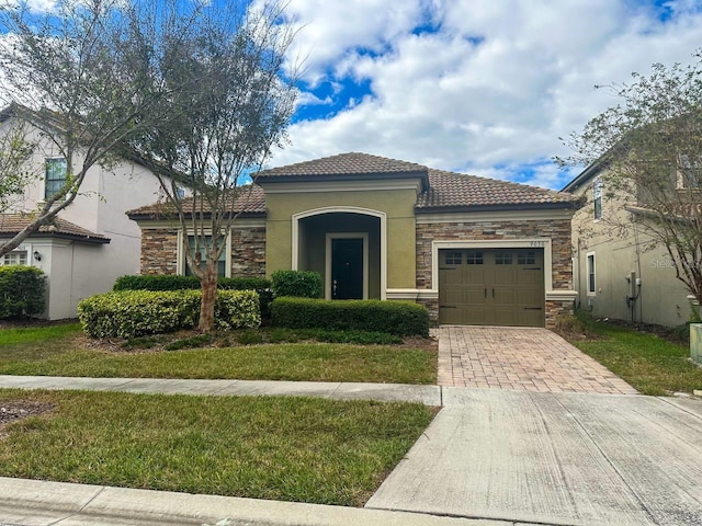 mediterranean / spanish home featuring a garage and a front lawn