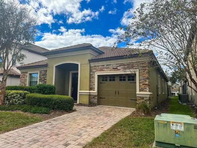 view of front of property with central air condition unit and a garage