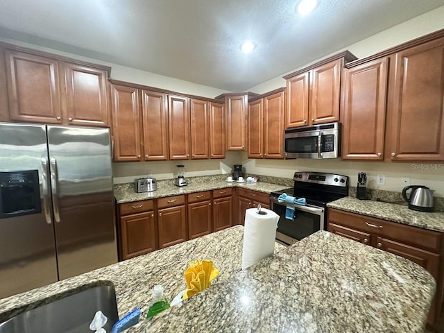 kitchen featuring light stone countertops and stainless steel appliances