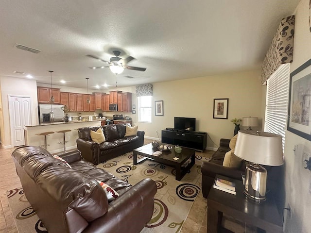 living room featuring a textured ceiling and ceiling fan