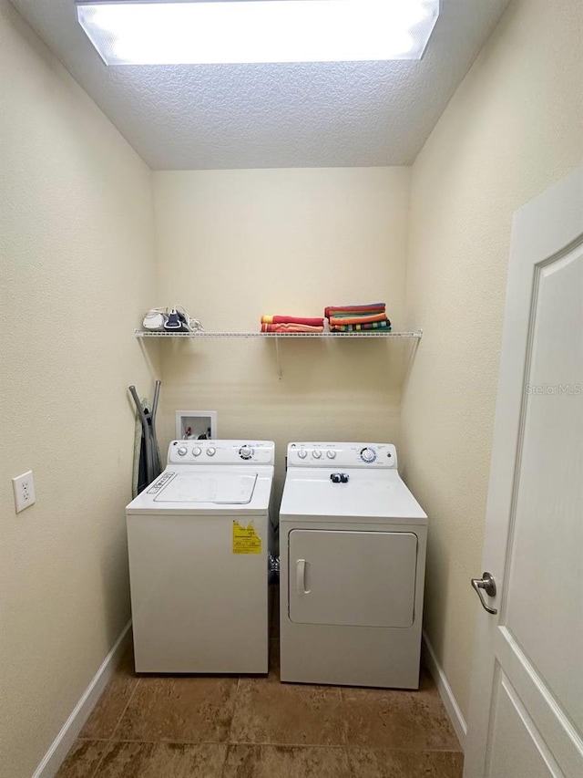 laundry area with separate washer and dryer and a textured ceiling