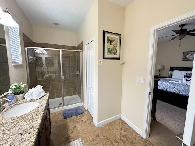 bathroom with a textured ceiling, vanity, walk in shower, and ceiling fan