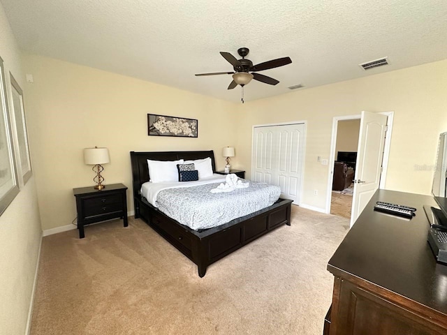 carpeted bedroom featuring ceiling fan, a textured ceiling, and a closet