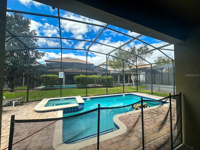 view of swimming pool with an in ground hot tub, a patio, a lanai, and a lawn